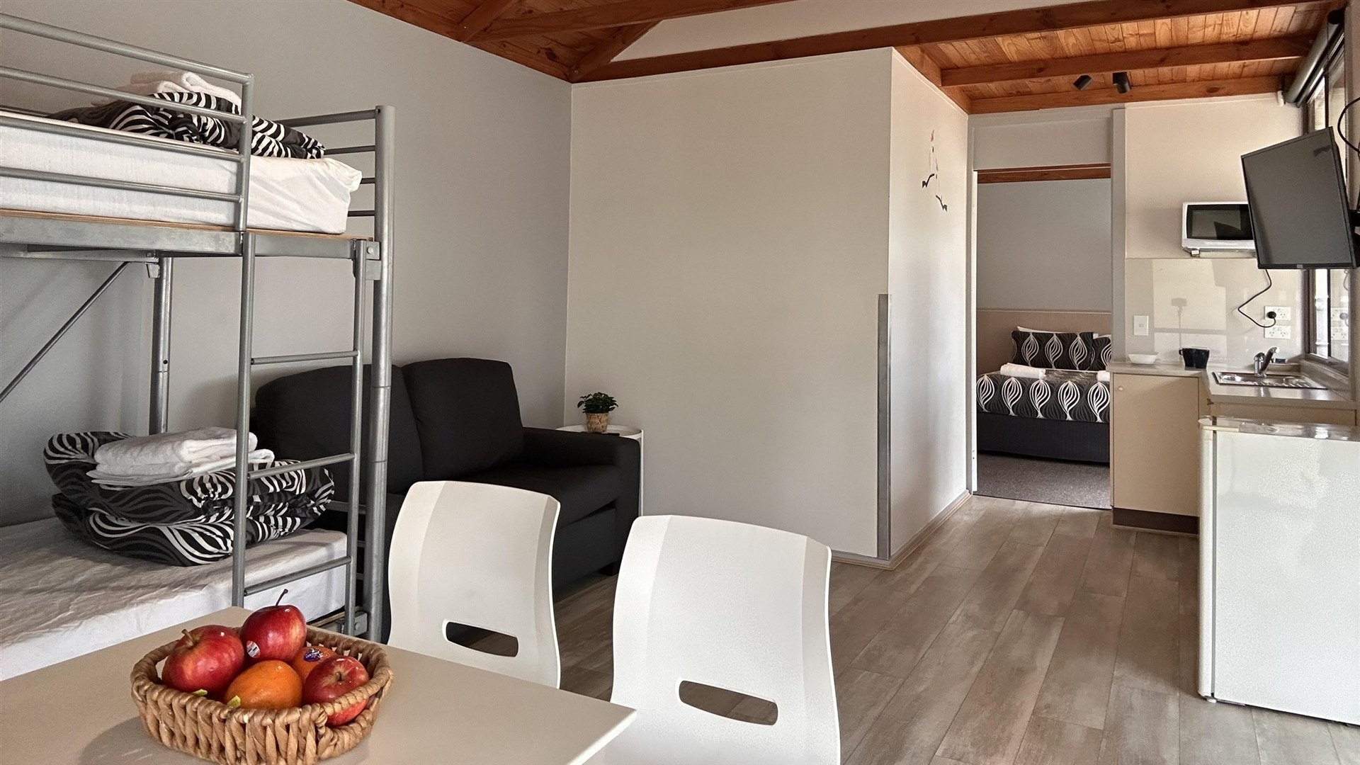 One Bedroom Cabin living area with kitchenette, dining table and bunk beds