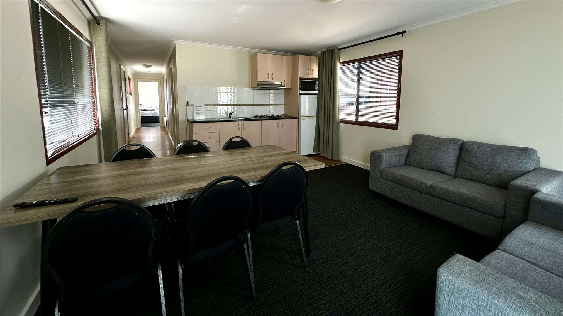 Two Bedroom Villa living area with a long dining table and the kitchen behind