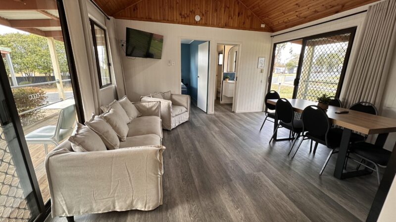 Cottage living and dining area with a sofa, dining table and raked timber ceiling