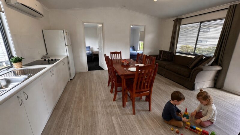 Two children playing on the floor of the Family Bungalow kitchen and dining area