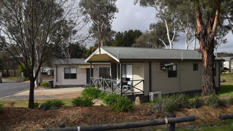 Two Bedroom Bungalow Large seen from the road, with gum trees around it