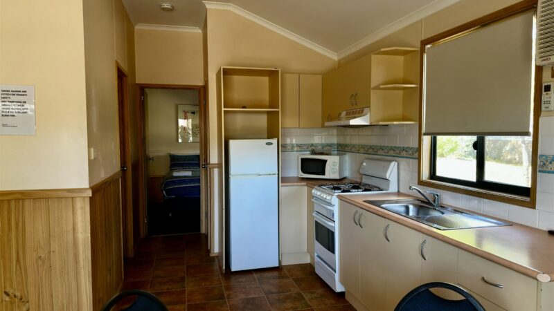 Large bungalow kitchen with oven, fridge and sink under the window