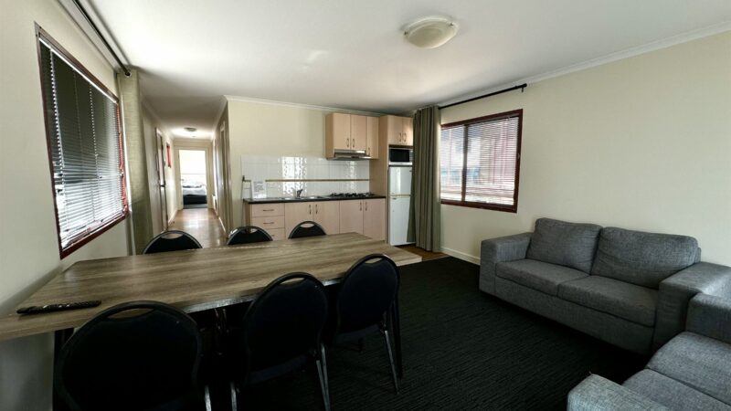 Two Bedroom Villa living area with a long dining table and the kitchen behind