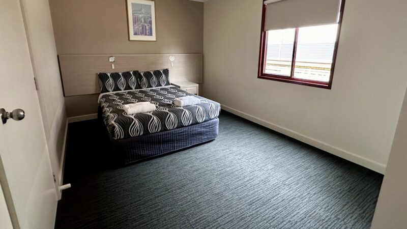 Two Bedroom Villa queen bedroom with a window beside the bed